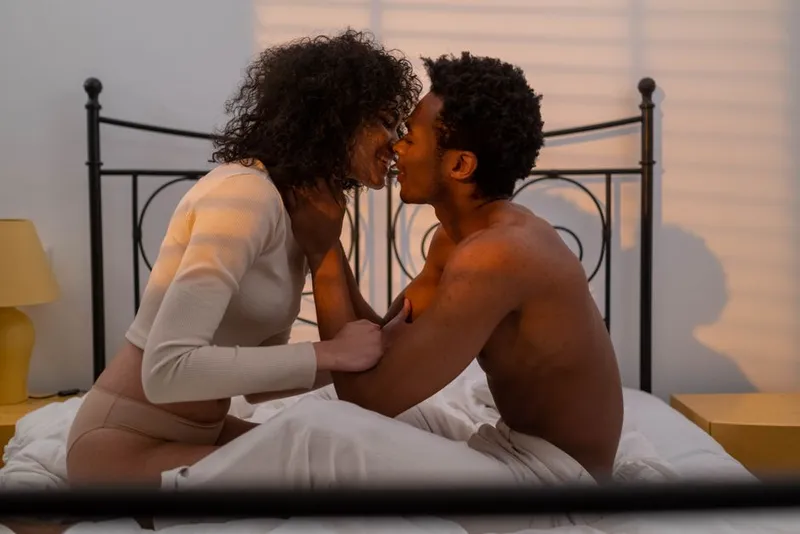 Couple in soft bedroom light, quiet and close together