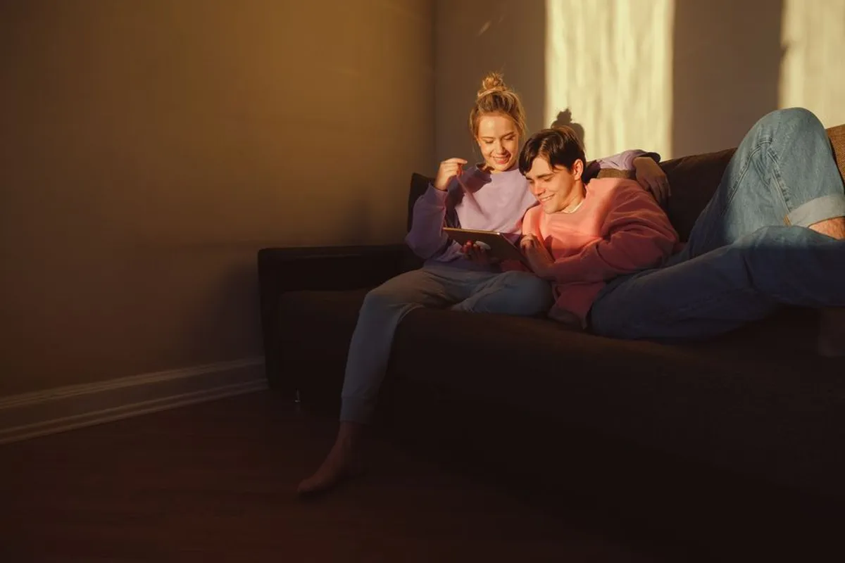 Couple relaxing together at home in warm evening light