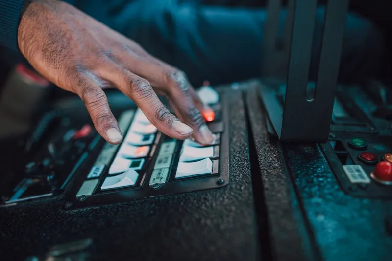 Hand pressing a button on a small device