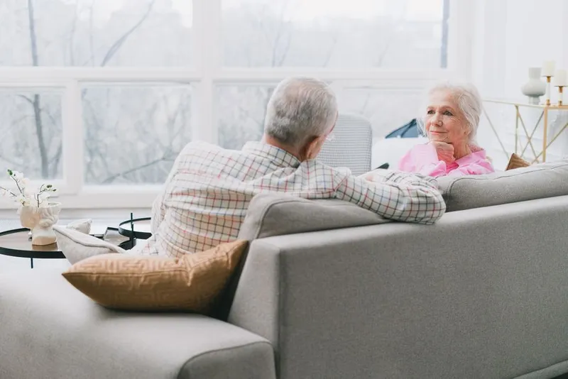 Couple in a gentle, honest conversation together on a sofa