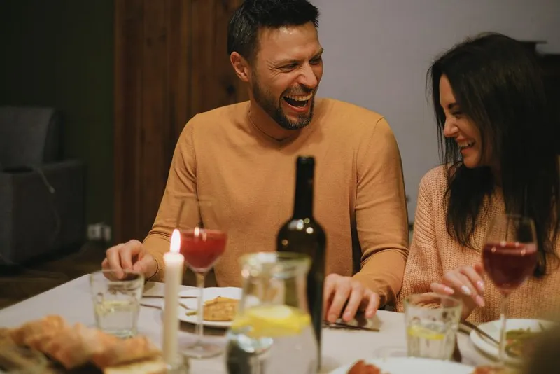 Couple laughing and relaxed together at home in the evening