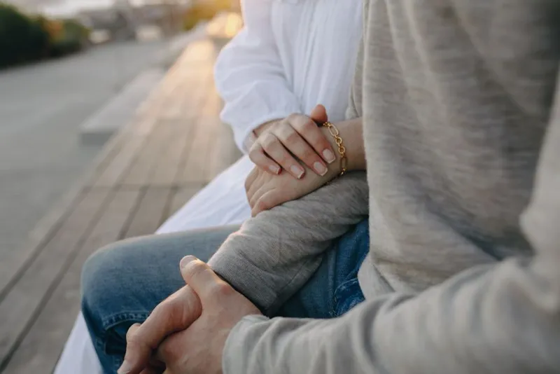 Two hands touching gently in soft light — responsive desire in relationships
