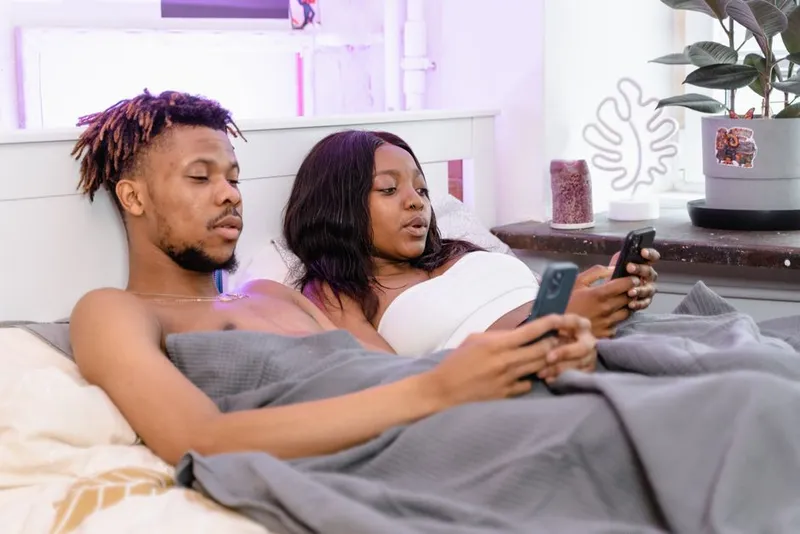 Two people answering privately on their phones at home