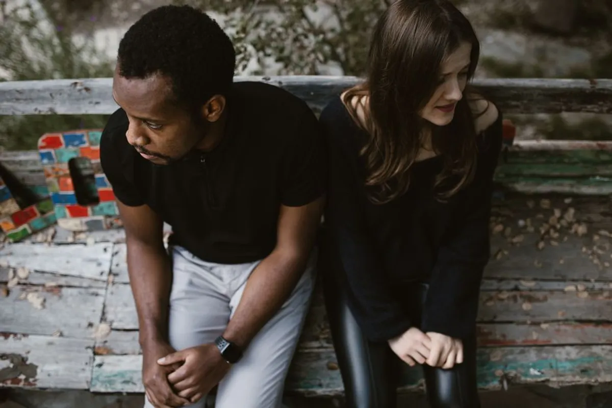 Couple sitting quietly apart on a sofa