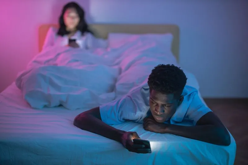 Two people answering privately on their phones at home