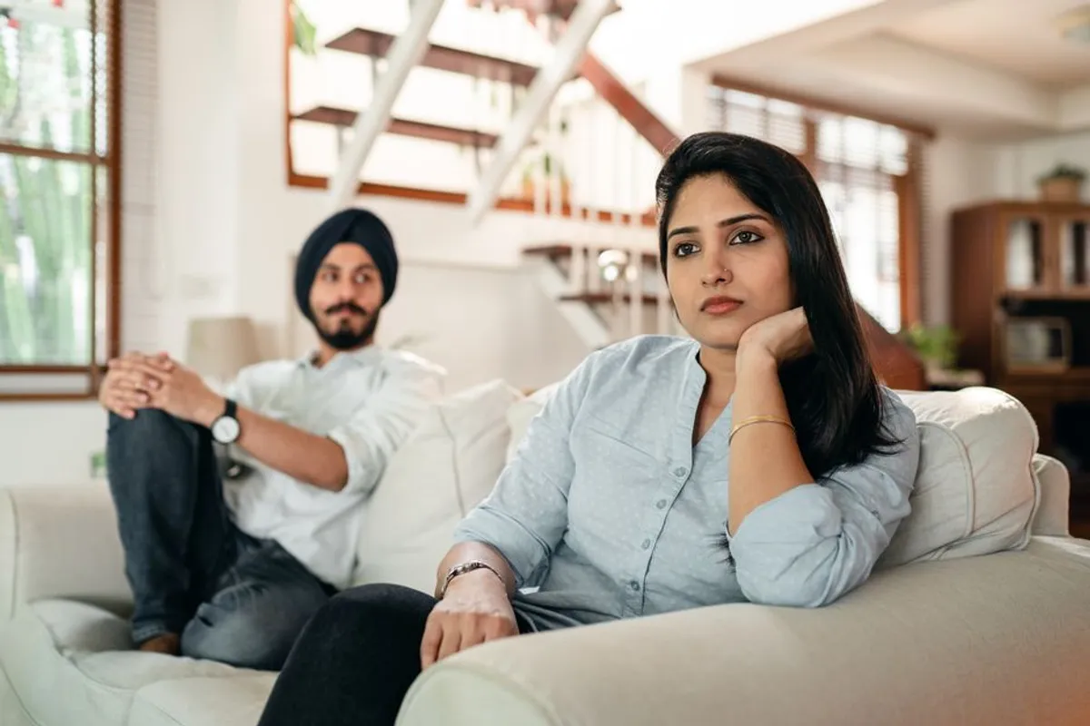 Couple sitting quietly apart on a sofa